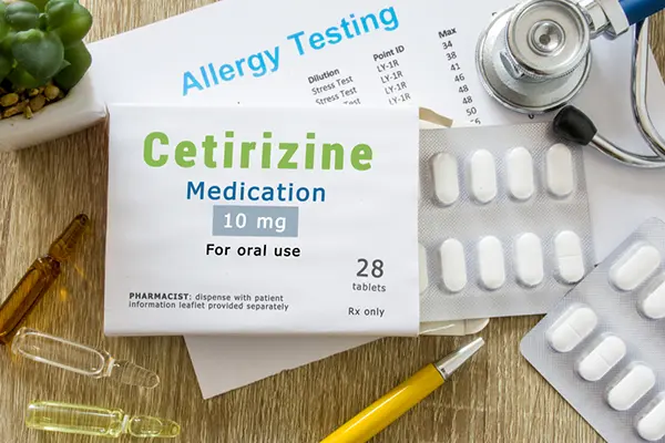 Different forms of cetirizine on a table next to an allergy testing form.