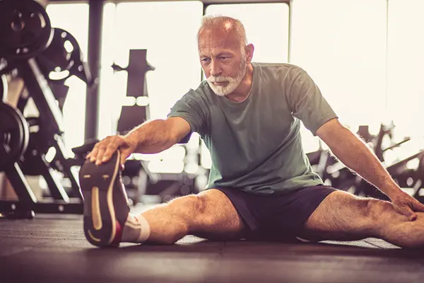 Older man stretching at the gym.