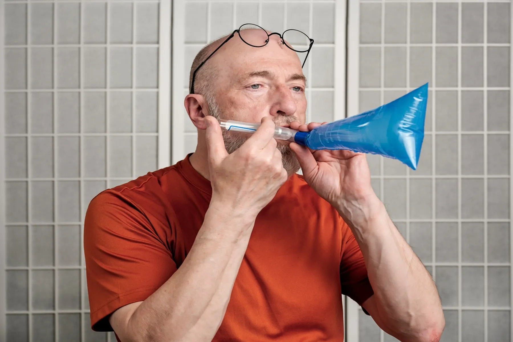 A man self-performs a hydrogen breath test to test for lactose intolerance.