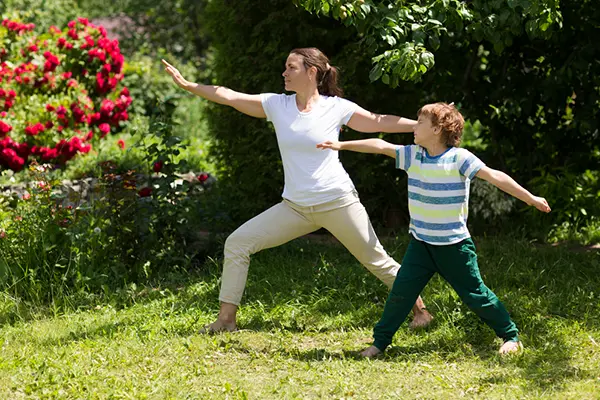 Mom and her son doing tai chi in a garden.