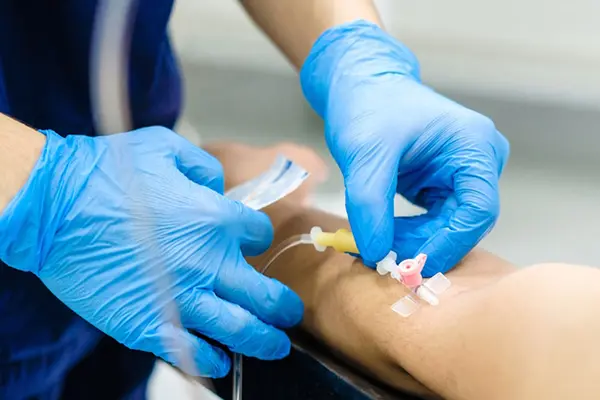 Doctor inserting an intravenous medication into a patient's arm.