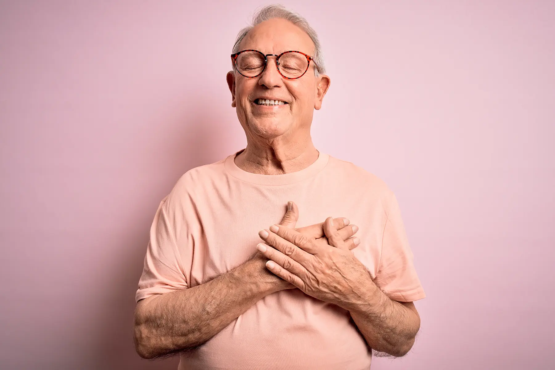 Old man smiling holding his heart