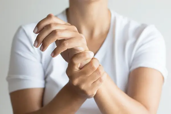 Woman squeezing her wrist in pain.