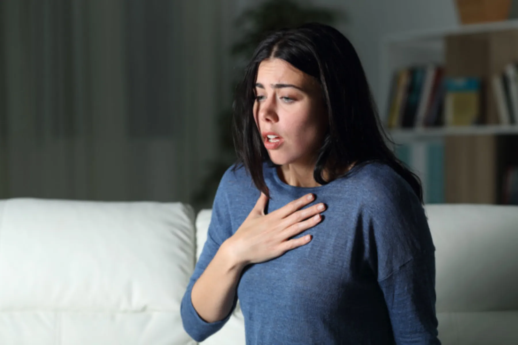 Woman looking panicked, with her hand on her chest