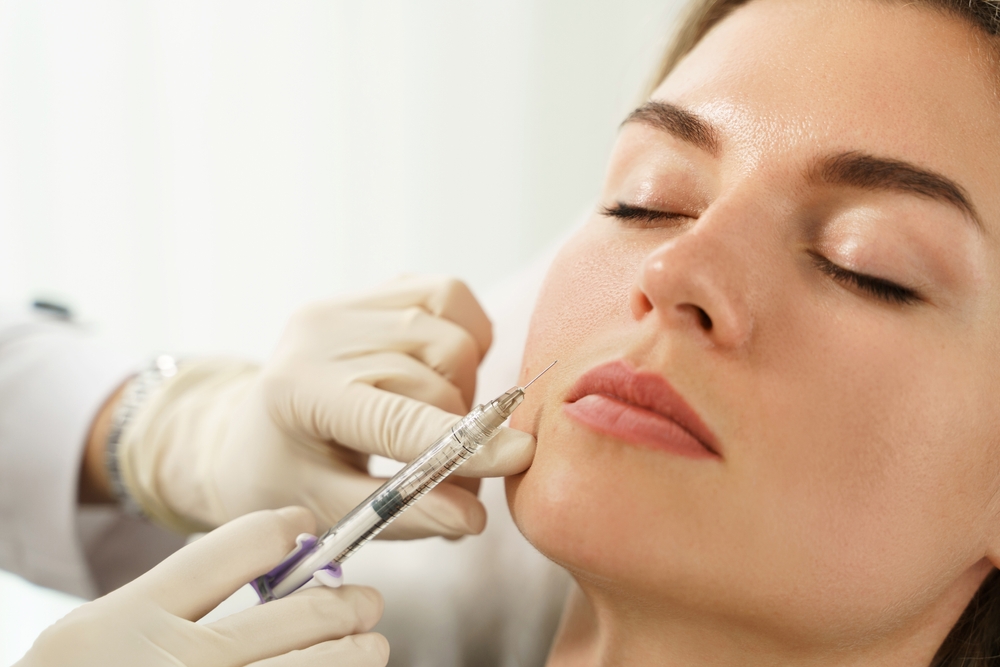 A young woman receives an injectable dermal filler.