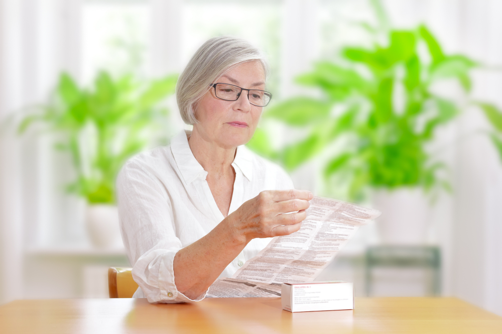 Older woman reading the instructions for a medication.