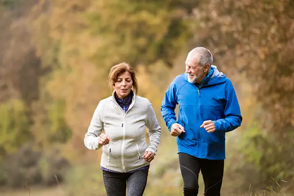An older couple takes an exercise walk outdoors.