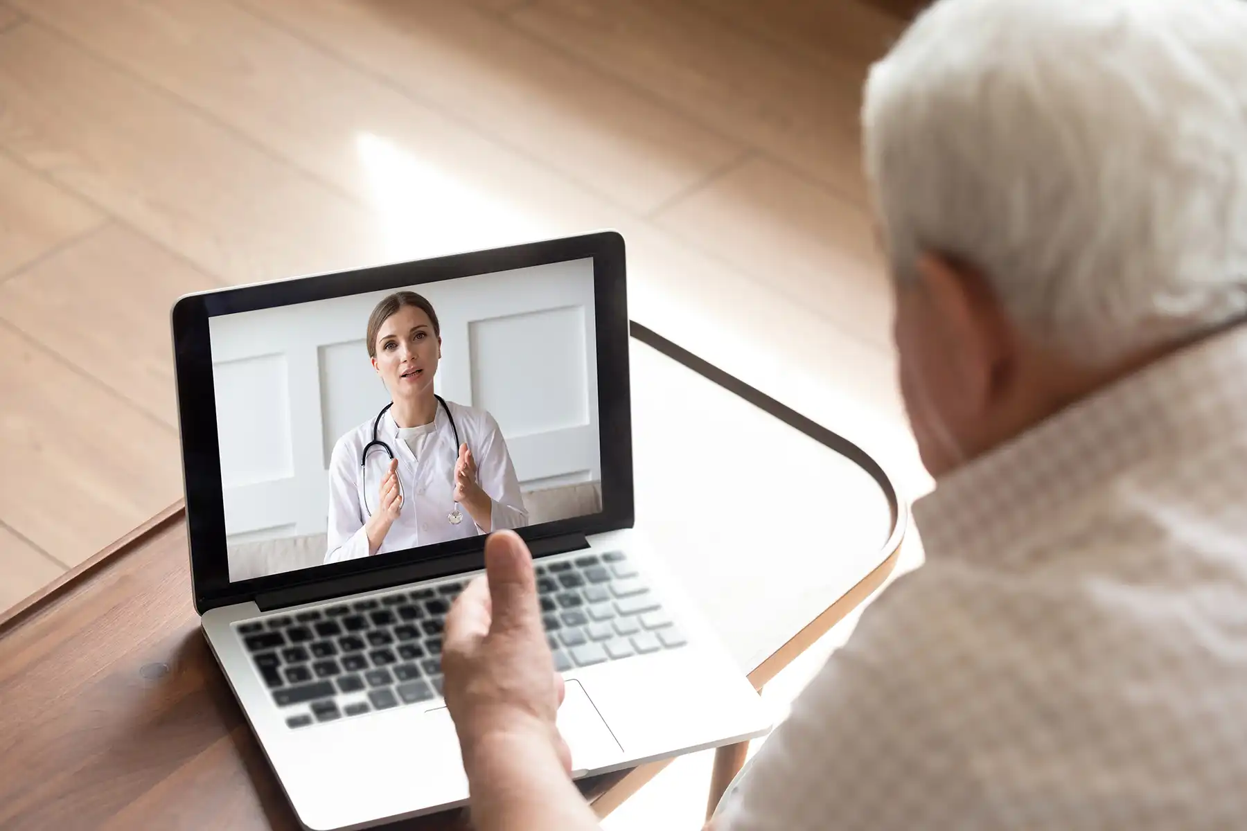 Older man on a virtual doctor's appointment from his laptop