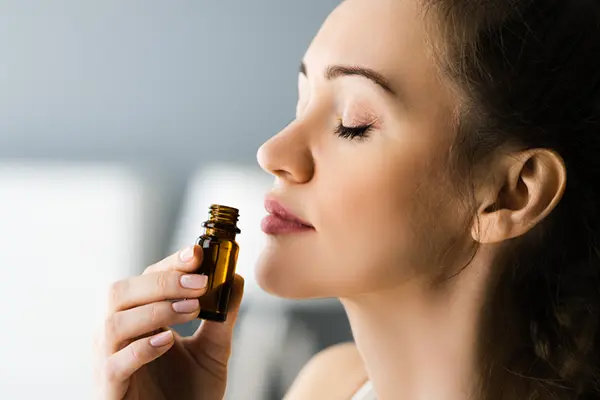 A woman smells an essential oil container