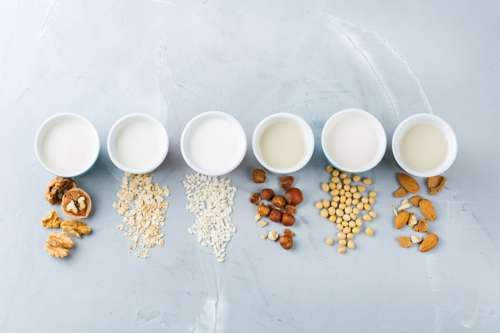 Assortment of alternative, lactose-free milks, including different nut and grain milks.