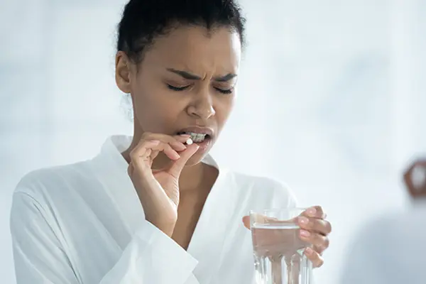 Woman taking medication with water.