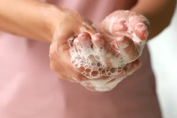 A close-up of hands lathered up with soap. 
