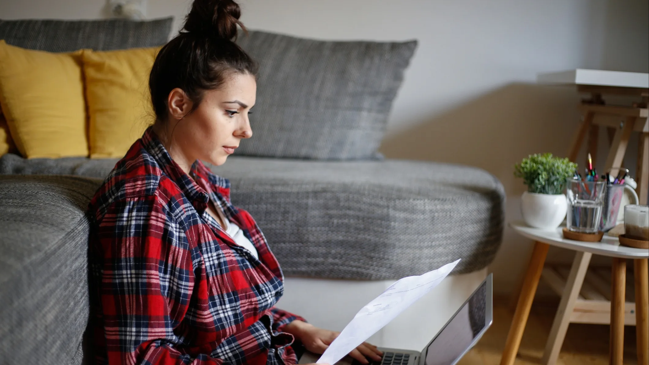 A woman sat on the floor looking at paperwork