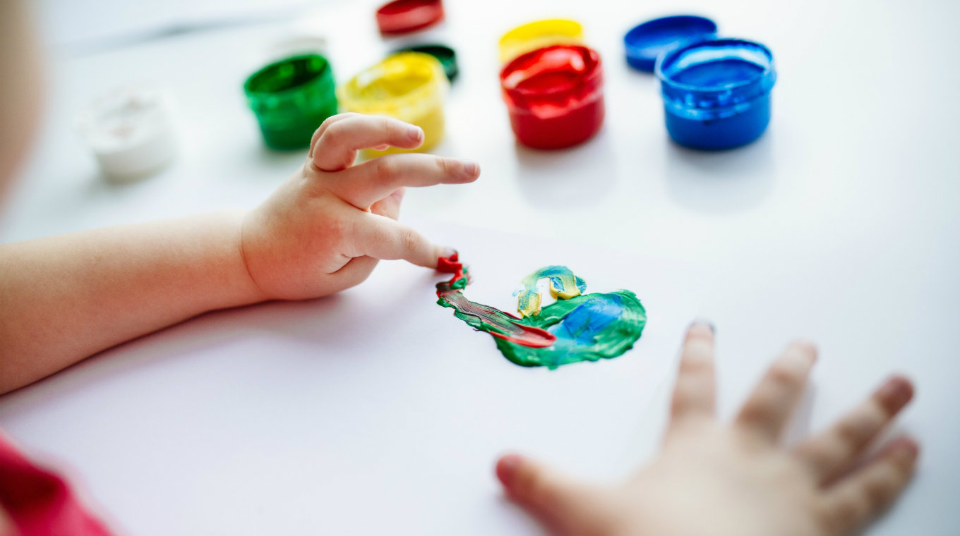 kid-hands-start-painting-at-the-table-with-art-supplies t20 YwvQV0
