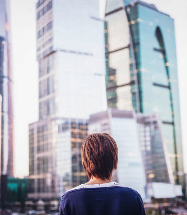 woman-looks-at-tall-buildings woman-looks-at-tall-buildings