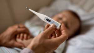 Parent takes sick child's temperature