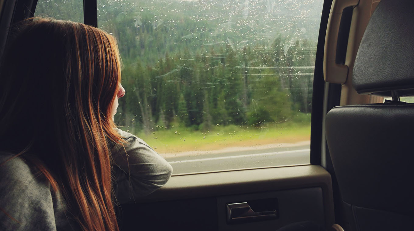 teen-girl-looking-out-car-window