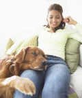 top-10-family-friendly-dogs7c - Woman Sits on a Sofa, Dog Resting His Head and Paw on Her Leg