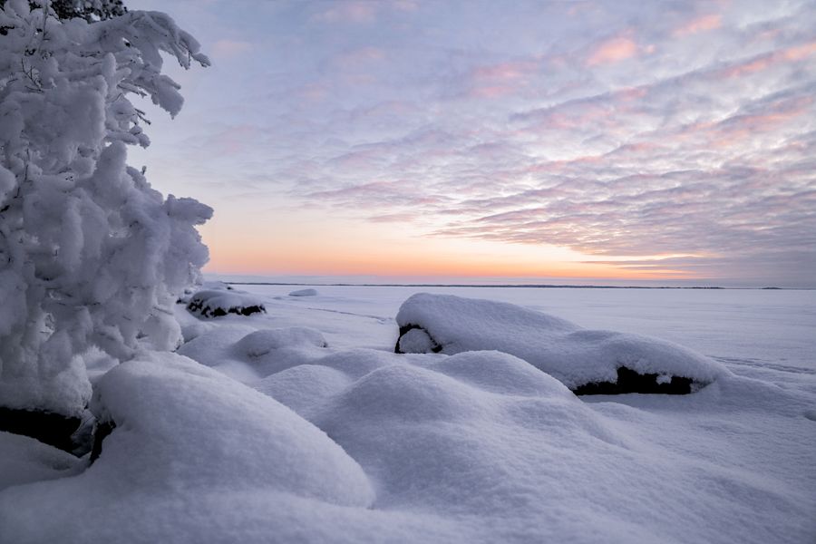Luminen valoisa talvimaisema jäätyneen järven päällä