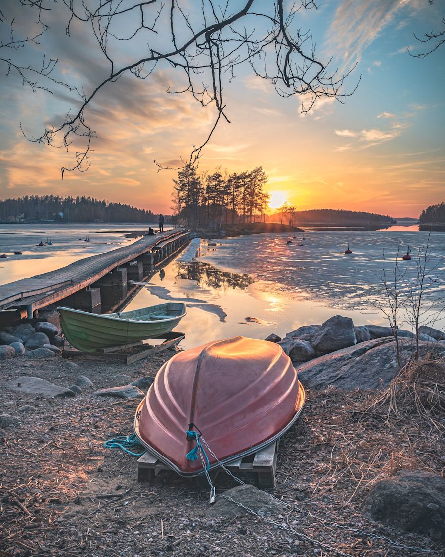 Soutuvene järven rannalla auringonlaskussa