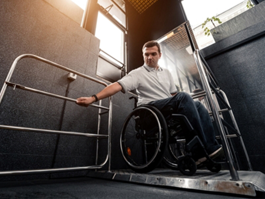 Rollstuhlfahrer auf einem Hublift.