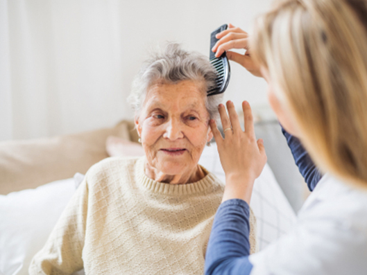 Pflegekraft kümmert sich intensiv um eine Patientin.