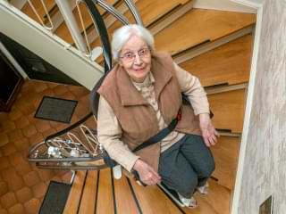 treppenlift-seniorin-geschwungene-treppe