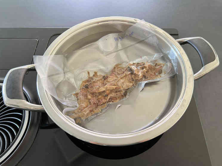 Gefrorenes Pulled Pork wird in einem Wasserbad aufgetaut und erwärmt