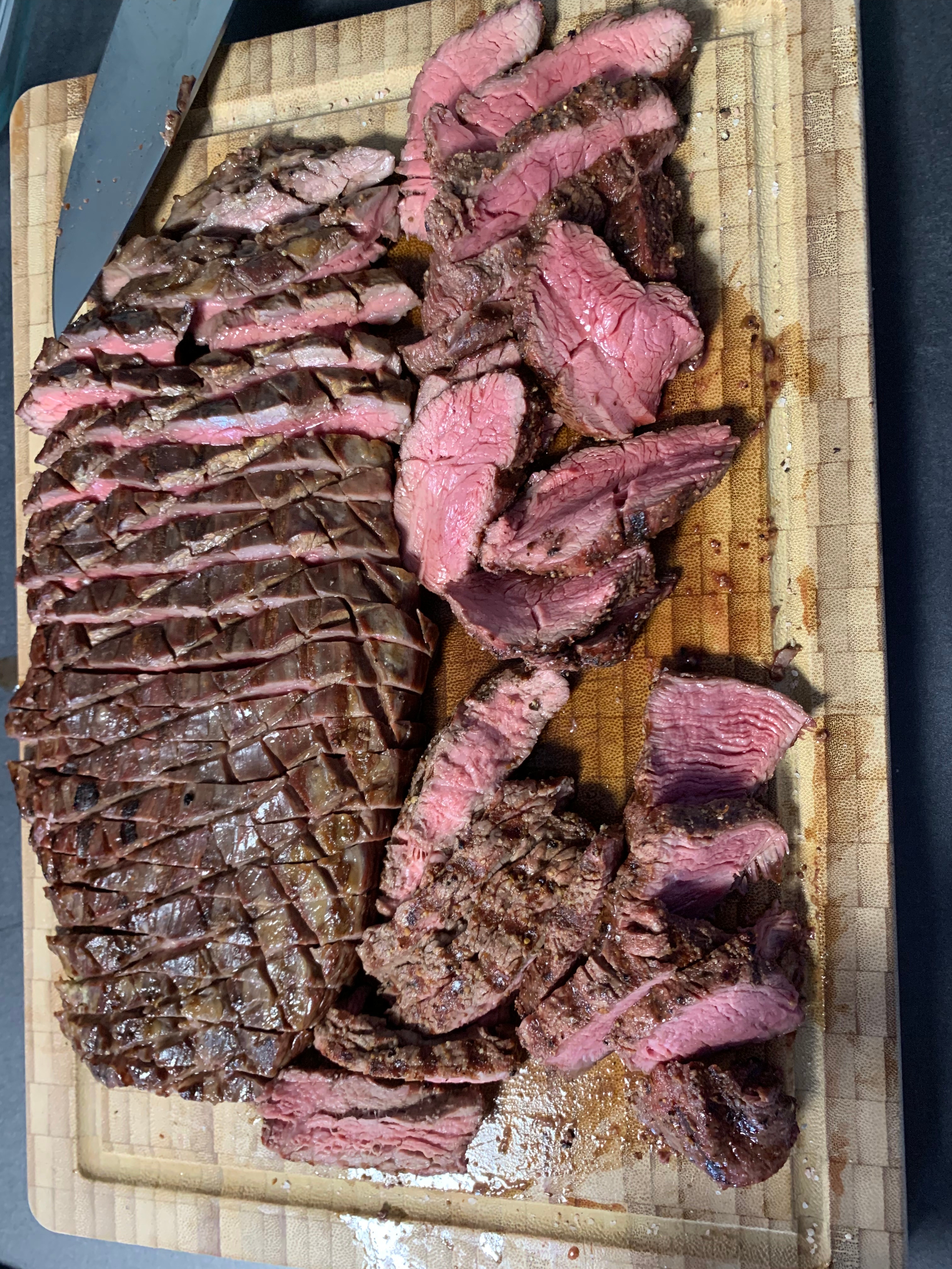 Flank Steak auf einem Holzbrett medium-rare aufgeschnitten