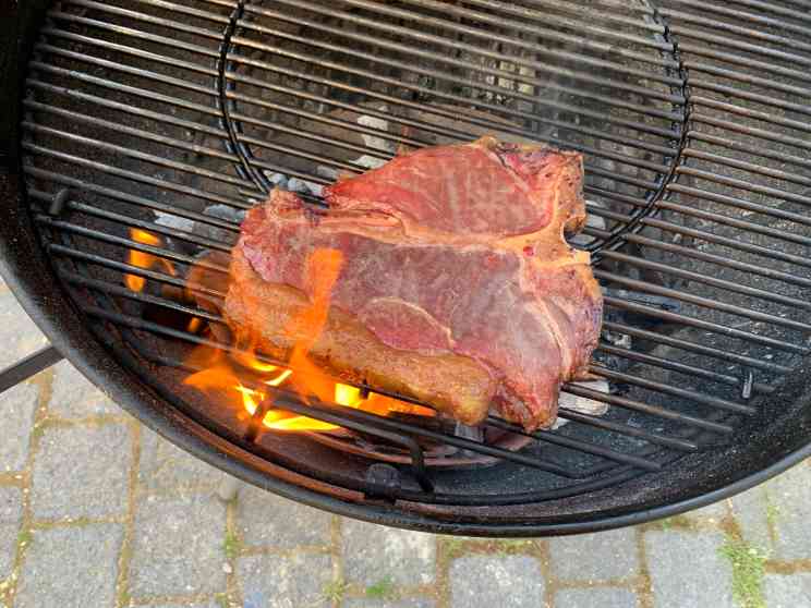 T-Bone Steak wird direkt über der heißen Kohle fertig gegart