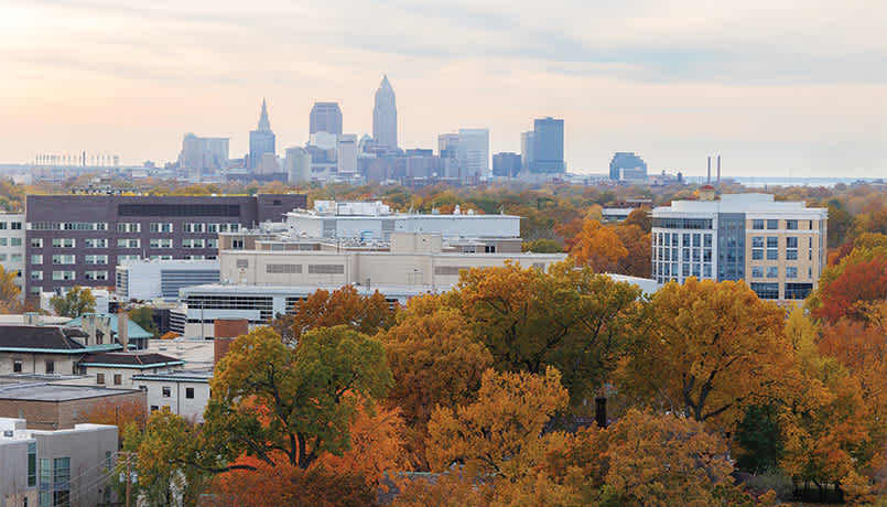 Case Western Reserve University’s campus from above with the Cleveland skyline in the background on a fall day.