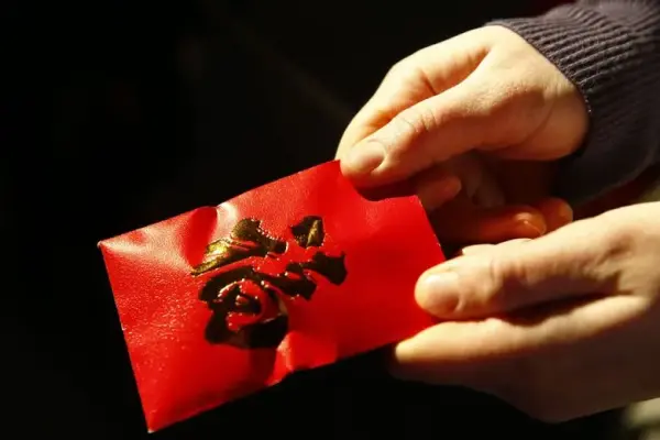 handing Lunar New Year red envelopes