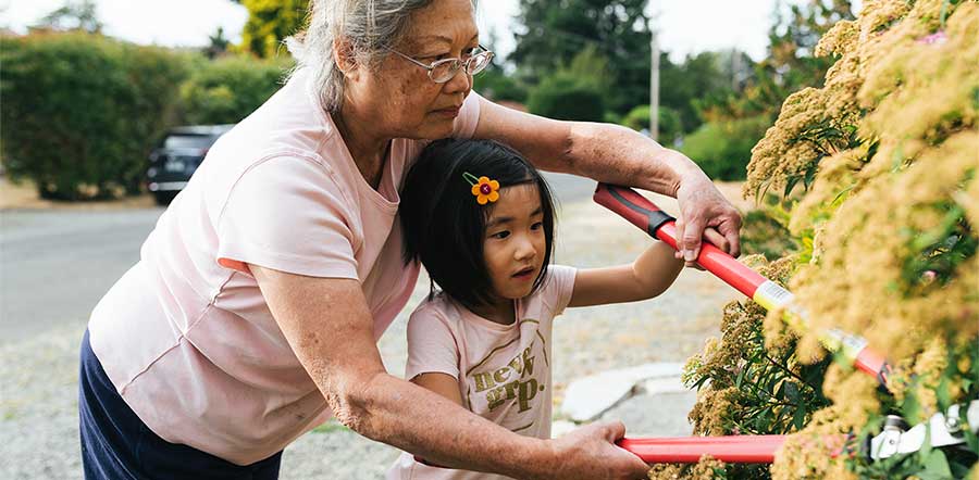 Een grootmoeder en haar kleindochter werken samen in de tuin