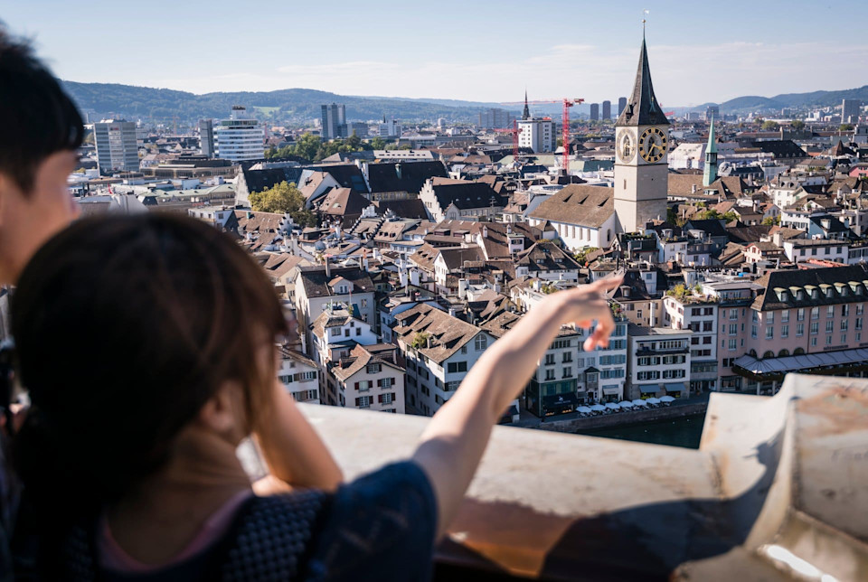 Zwei Menschen schauen auf eine Schweizer Stadt.