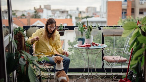 Tragbarkeitsrechnung: Frau mit Hund auf Balkon