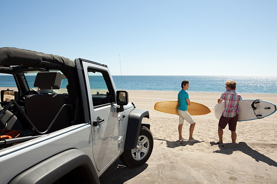 Autoversicherung im Ausland - zwei Männer fahren an Strand