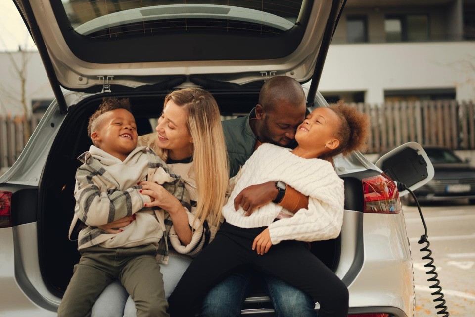 Familie ladet Auto und ist glücklich