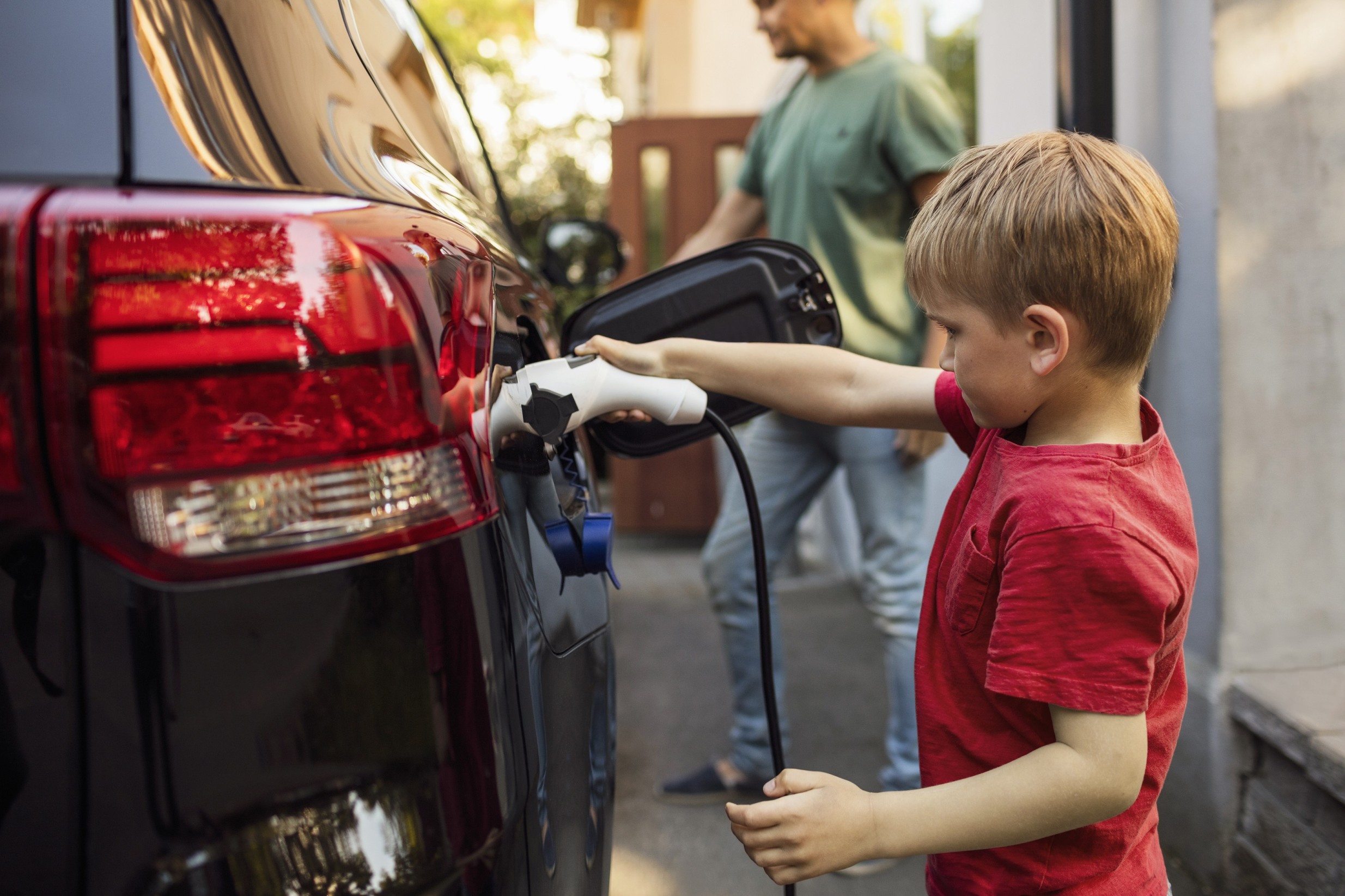 Autoversicherung für Elektroautos: Kind lädt Auto