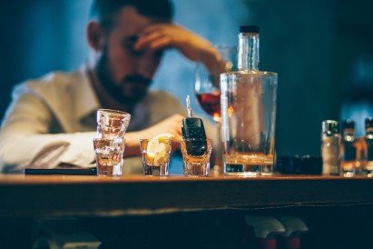 Alkohol am Steuer: Mann mit Drinks und Autoschlüssel an der Bar