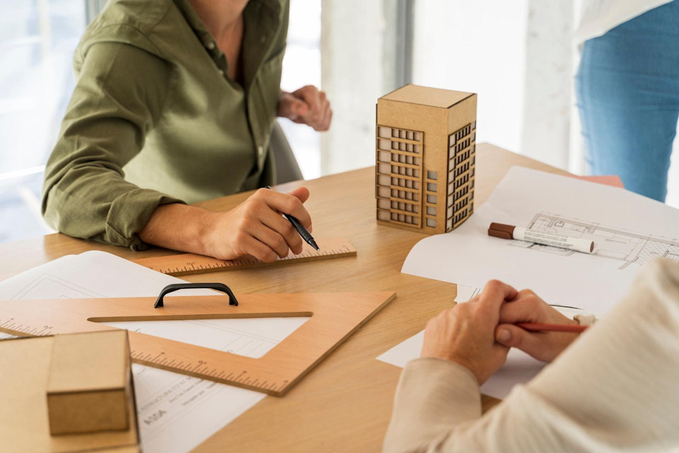 Zwei Personen sitzen am Schreibtisch und planen die nächste Wohnung oder Haus.