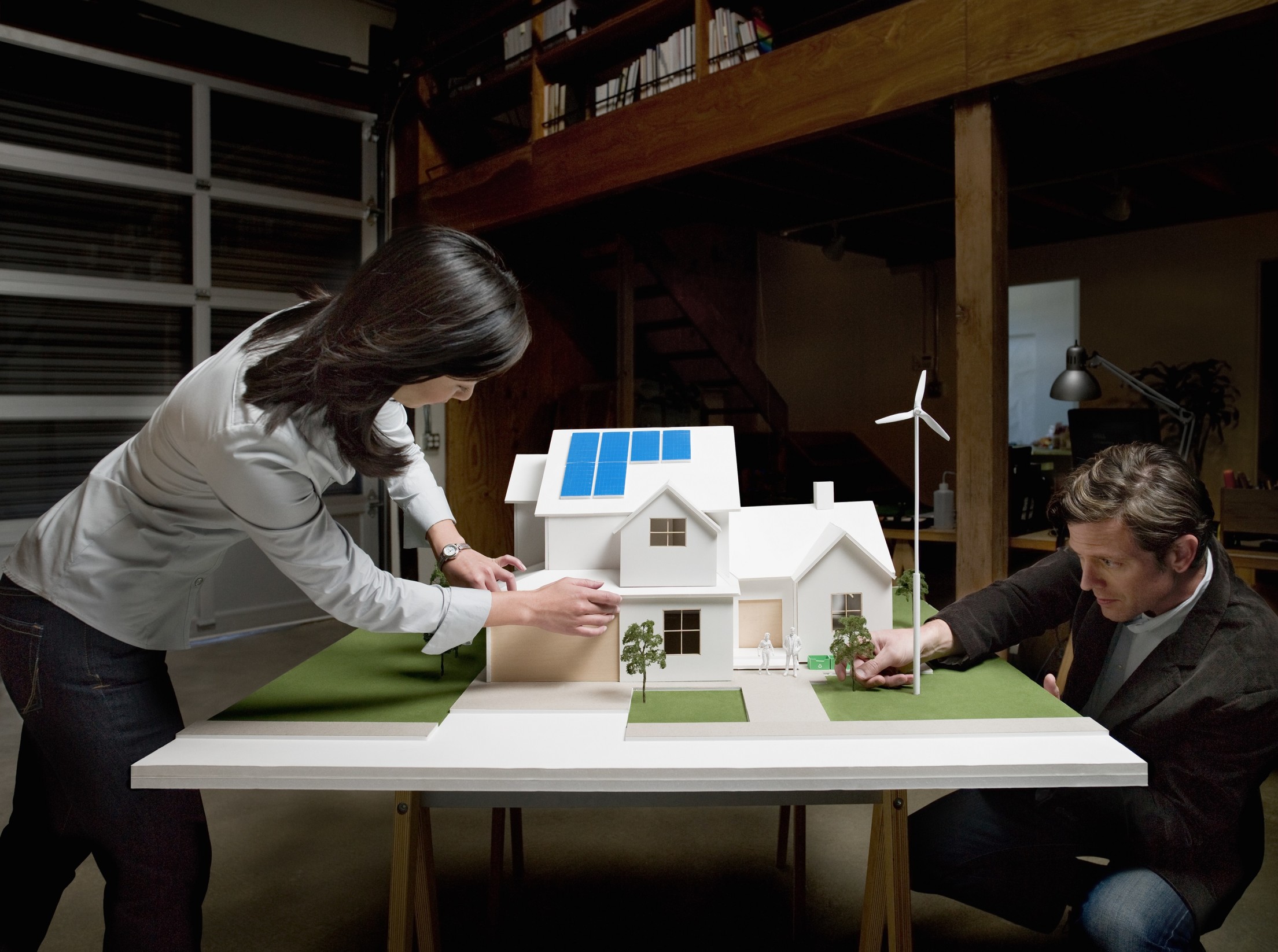 Architektin und Architekt bauen ein Modellhaus