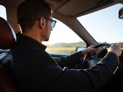 Leasingauto richtig versichern: Mann fährt Auto