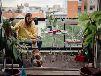 Tragbarkeitsrechnung: Frau mit Hund auf Balkon