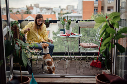 Calcolo della sostenibilità: donna con cane al balcone