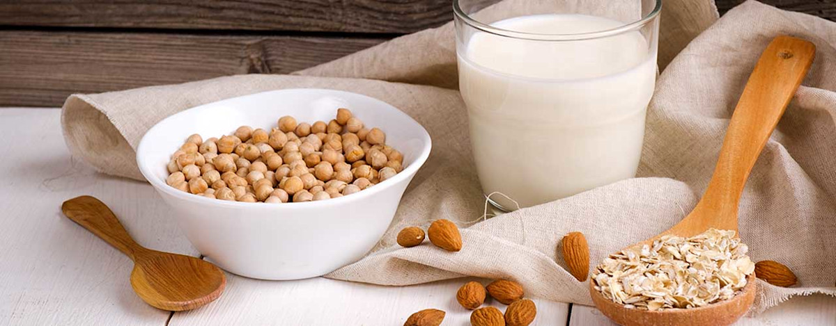 Bild von Hülsenfrüchten, Nüssen und Haferflocken auf einem beigen Tuch