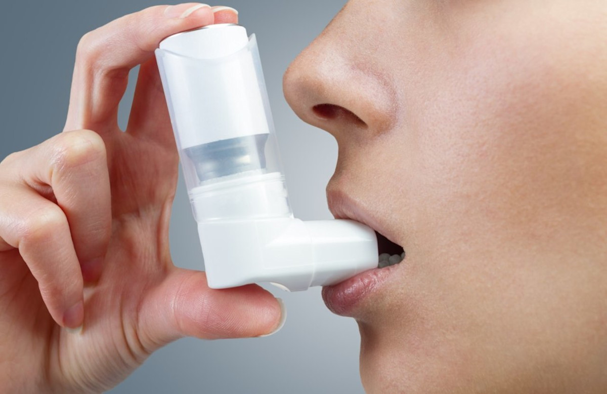 Frau verwendet Asthma-Spray mit Inhalator.