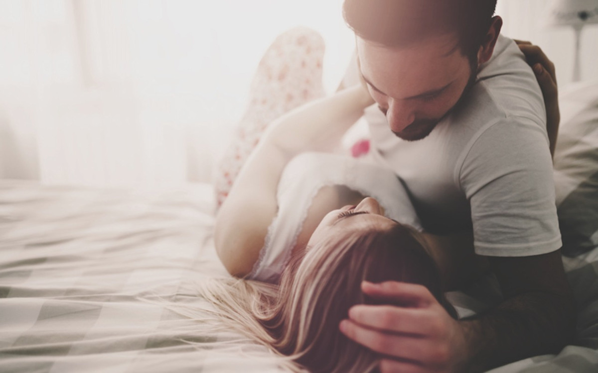 Ein verliebtes Paar liegt zusammen auf dem Bett.