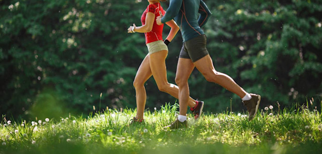Junges paar joggt im Frühling in der Natur.