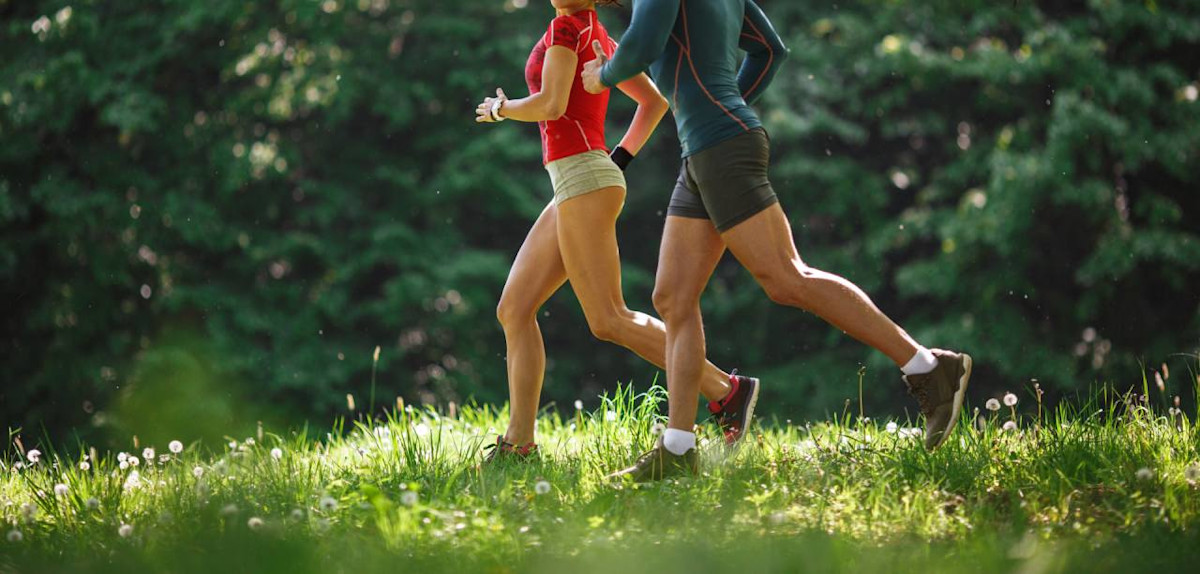 Junges paar joggt im Frühling in der Natur.