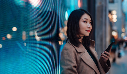 Japanese woman looking at her smartphone outside